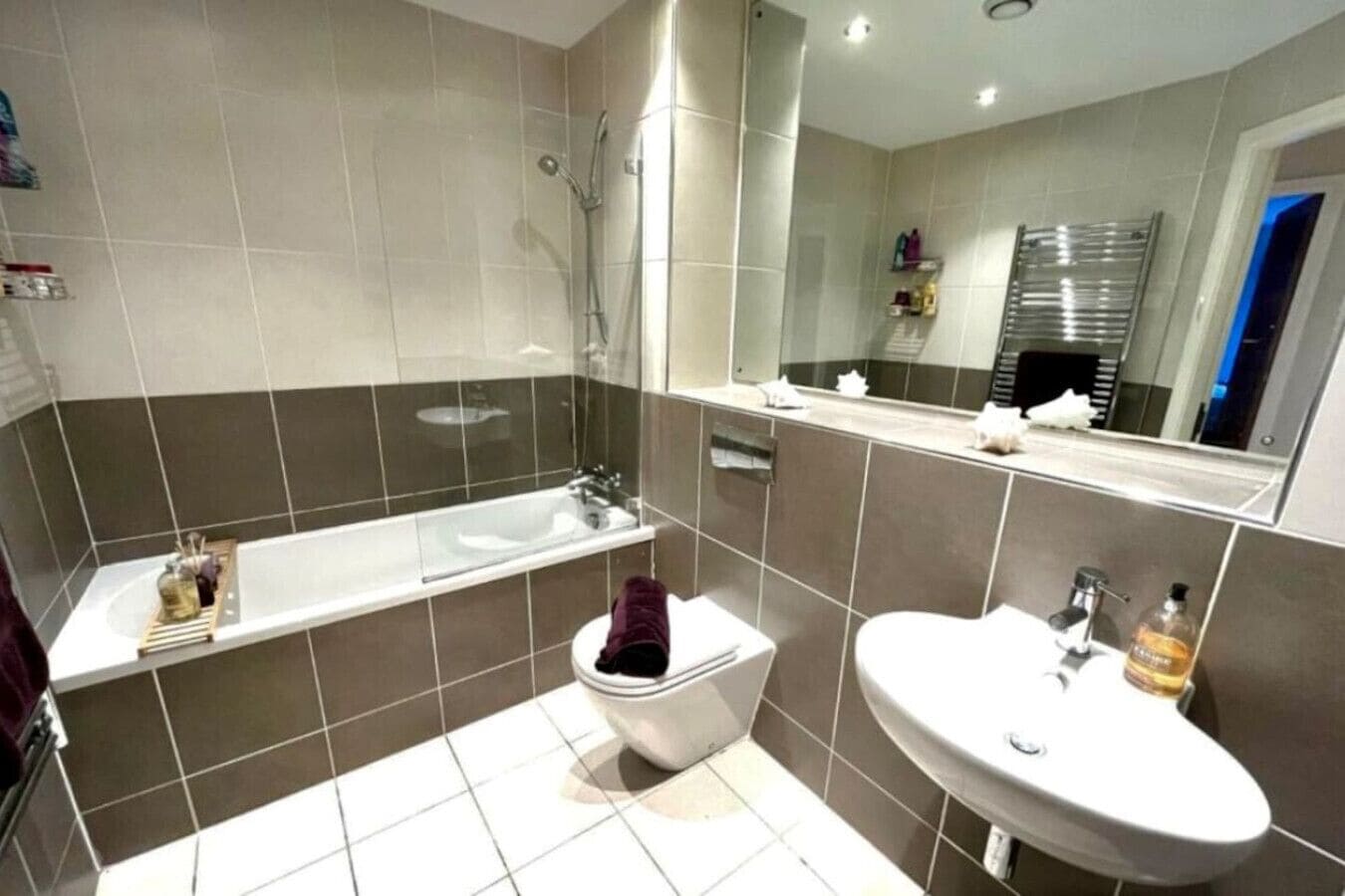 A modern bathroom with a bathtub, toilet, and sink.