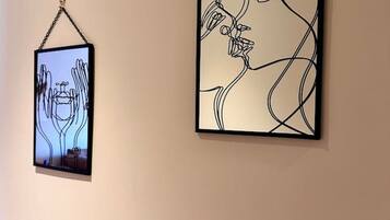 Two framed artworks hanging on a plain wall.