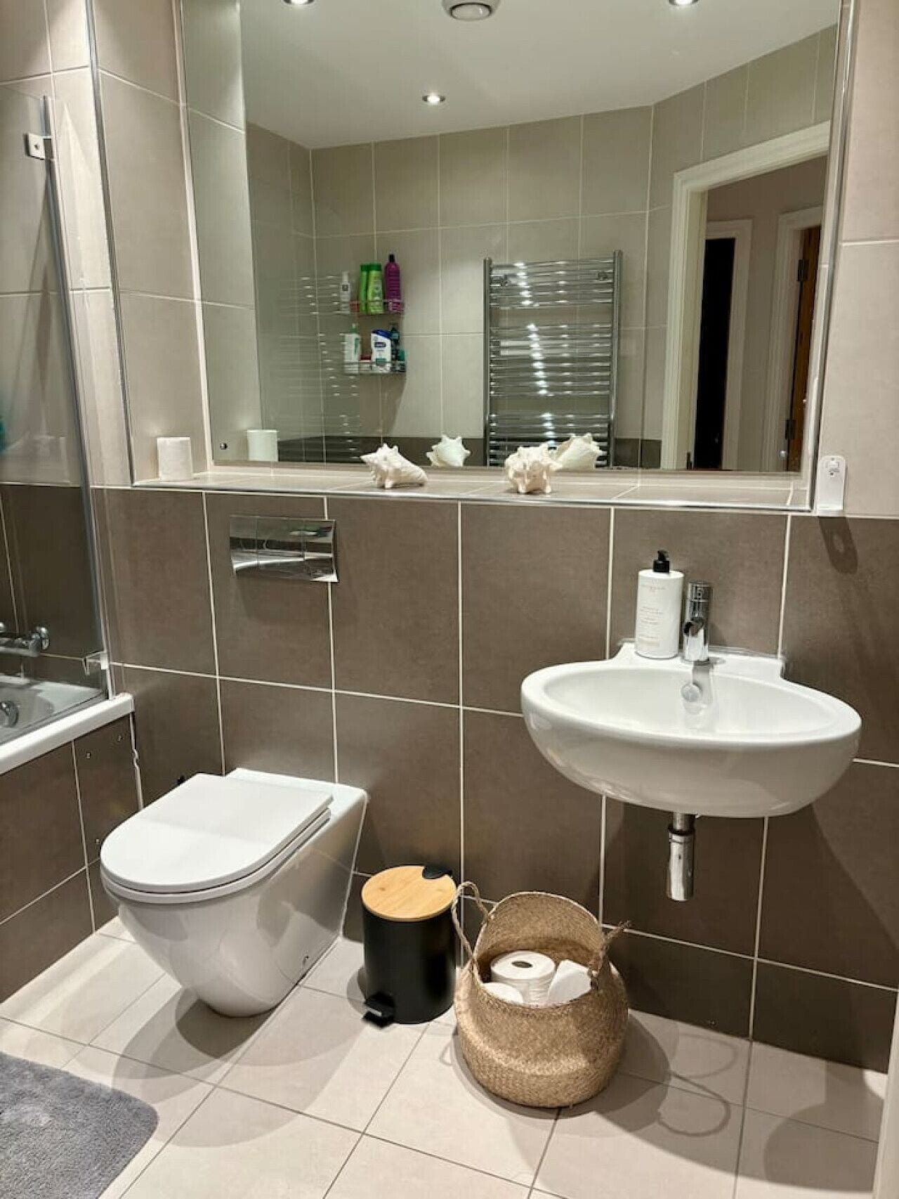 Et moderne badeværelse med toilet, vask og bruser.