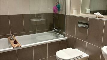 Un baño moderno con ducha de vidrio, inodoro blanco y bidé.