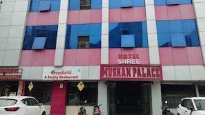 A multi-story building with a pink and blue facade. The ground floor features a restaurant named "Sanskriti" and a hotel named "Muskan Palace". - Hotel Shree Muskan Palace (Ujjain)