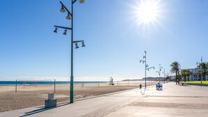 A beach with a clear sky, a volleyball net, and a lifeguard tower. - MARE INTERNUM II (La Pineda)