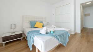 A modern bedroom with a bed, bedside tables, and a wardrobe. - BELL RACÓ Superior (La Pineda)