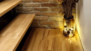A corner with a brick wall, a wooden bench, and a vase with dried flowers. - 2-bedroom house with Hot Tube, AC, WiFi. Enjoy a cozy stay near river. (Netretić)