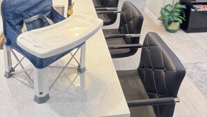 Une cuisine moderne avec un coin repas, comprenant une chaise haute et des chaises.