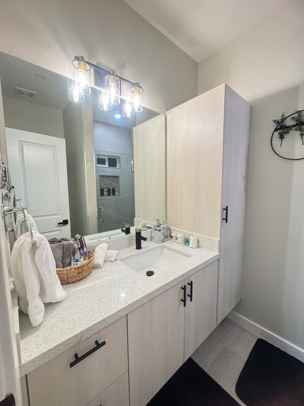 Un baño moderno con un espejo grande, un lavabo y un perchero para toallas.