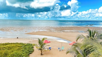 På stranden, vit sandstrand, solstolar och parasoller