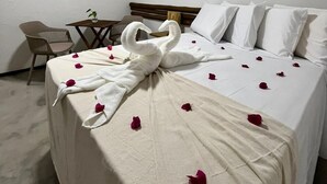 Quarto de hotel com cama, escrivaninha e cadeira.