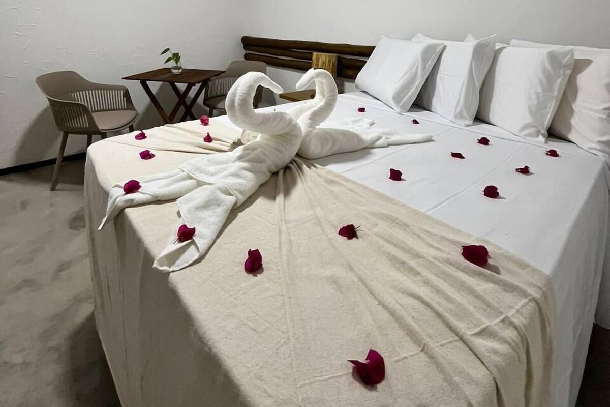 A hotel room with a bed, a desk, and a chair.