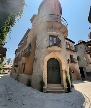 Un bâtiment doté d’une structure en forme de dôme unique, d’une entrée centrale surmontée d’une arche et d’un balcon agrémenté d’une rambarde en métal.