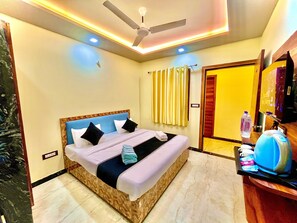 A hotel room with a bed, a ceiling fan, a shower area, and a bathroom with a toilet and sink. - YS TAJ HOTEL AGRA (Agra)