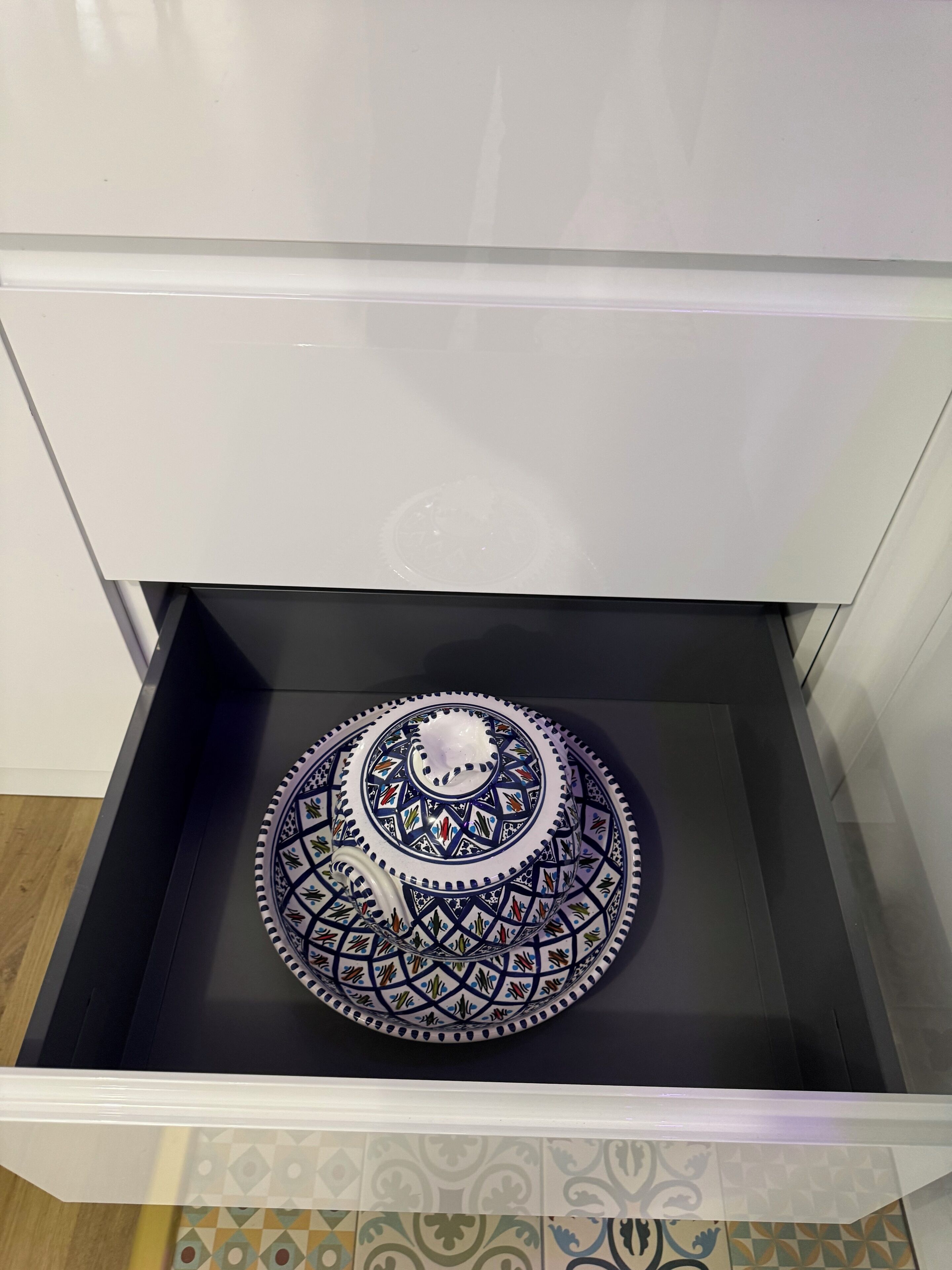 A drawer with a decorative plate inside.