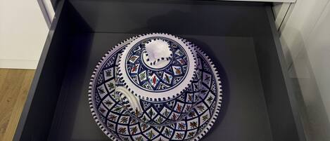A drawer with a decorative plate inside.