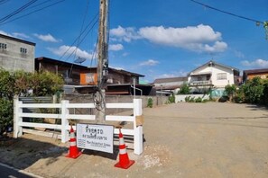 A residential area with houses, a white fence, and a sign. - The Folkster House Chiangkhan (Chiang Khan)