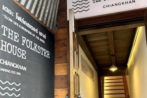 A wooden interior with a sign for 'The Folkster House' and a ceiling with exposed beams. - The Folkster House Chiangkhan (Chiang Khan)