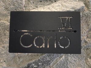 Una placa negra con el nombre 'Carlo' y el número romano 'VIII' grabado.