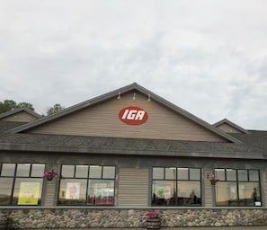 Ein Gebäude mit einem gut sichtbaren IGA-Logo auf dem Dach, großen Fenstern und einer Steinsockel.