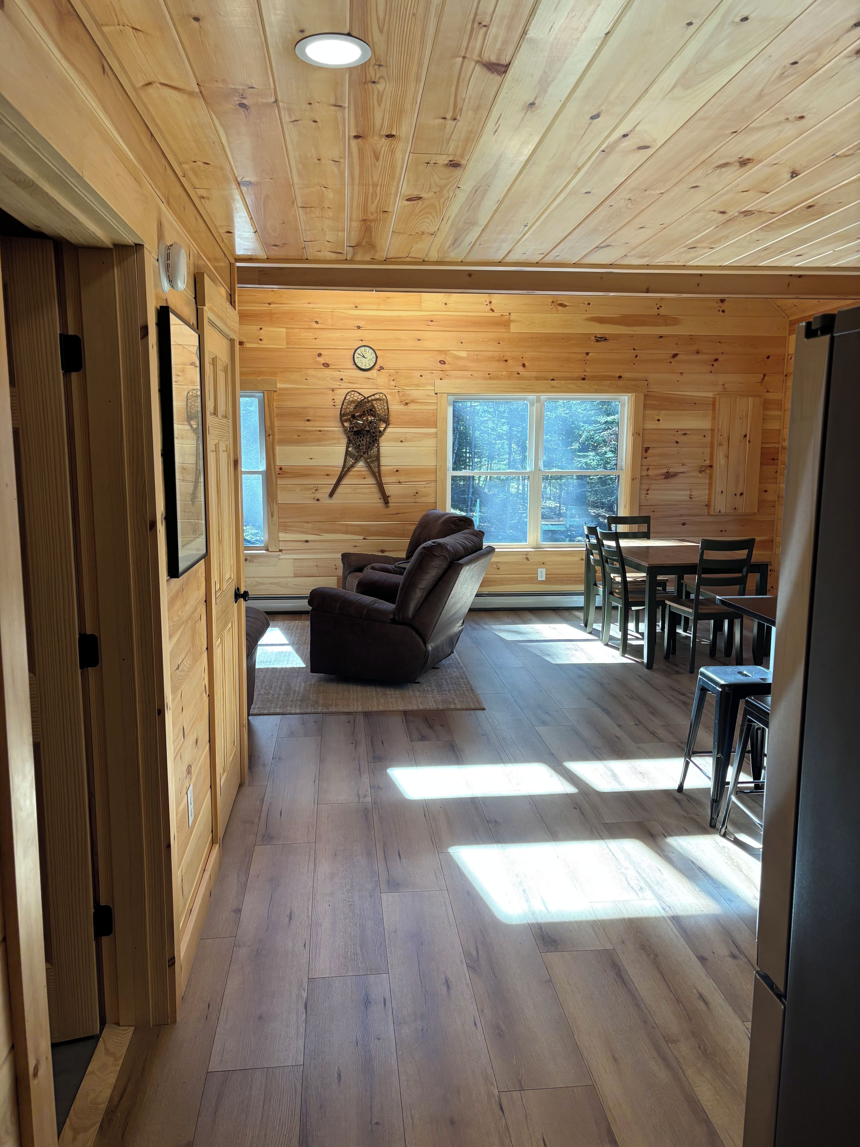 Un intérieur en bois comprenant un canapé, une table à manger et des chaises.