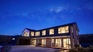 A modern two-story house with large windows and a garage. - Stargazing Tekapo Apartment (Lake Tekapo)