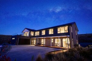 Una casa moderna de dos pisos con ventanas amplias y un garaje.