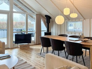 A modern dining area with a wooden table, black chairs, and pendant lights. - 4 Star Holiday Home in Sydals (Sydals)