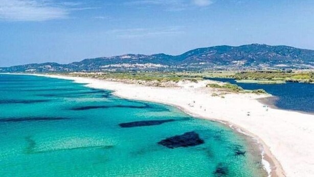 A coastal landscape with a beach and clear turquoise waters. - Maya House. (La Ciaccia)