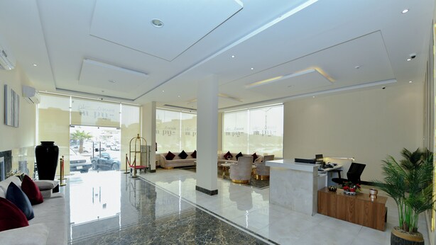 A modern hotel lobby with a marble floor, a reception desk, seating area, and large windows. - أونيسن للشقق المخدومة Onsen Serviced Apartments (Al Kharj)