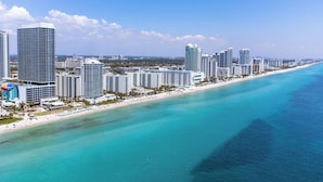 A coastal cityscape with high-rise buildings, a beach, and clear turquoise waters. - The Sky is the Limit: Picturesque Condo on a High Floor!!! (Hollywood)