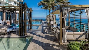 A poolside area with lounge chairs and a pool, overlooking the ocean. - The Sky is the Limit: Picturesque Condo on a High Floor!!! (Hollywood)
