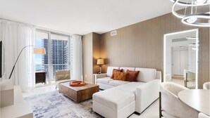 A modern hotel room with a large window, a sofa, a coffee table, and a dining area. - The Sky is the Limit: Picturesque Condo on a High Floor!!! (Hollywood)