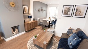 Un salon moderne avec une table basse en bois, un canapé et un coin repas comprenant une table et des chaises.