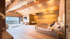 A spacious room with a wooden ceiling, a sofa, a small table, and a view of the outdoors.