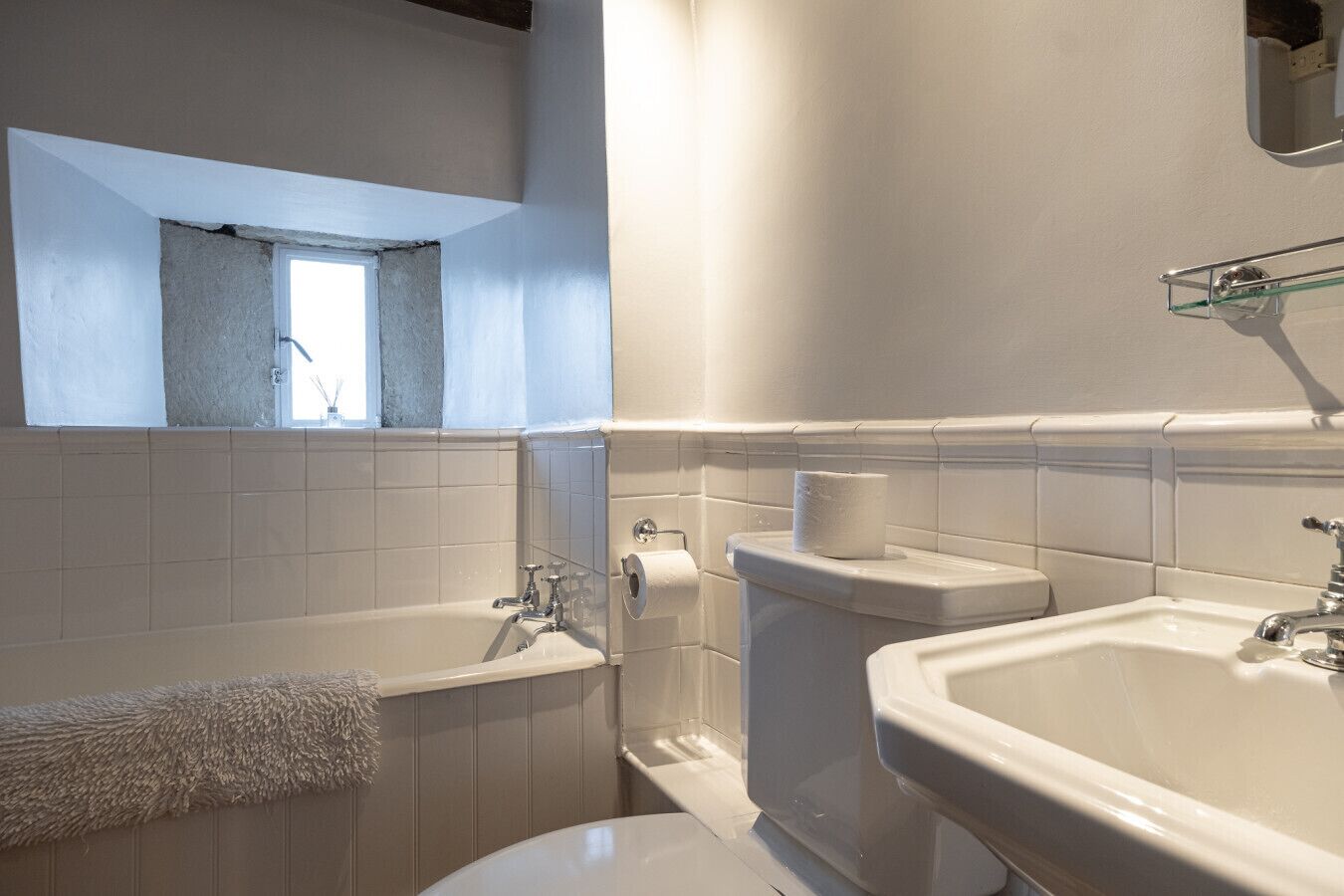 A bathroom with a bathtub, toilet, and sink.
