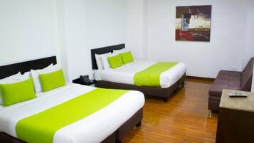 A hotel room with two beds, a desk, and a painting on the wall.