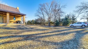 A house with a covered porch and a car parked in the driveway. - Covered Porch & Grill: 1-Acre Property in Bristow! (Bristow)