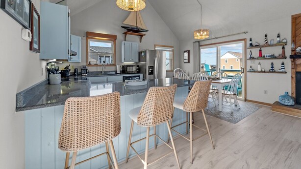 Een ruime keuken met een groot eiland, barkrukken en moderne apparatuur.