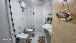 A bathroom with a toilet, bidet, and sink. - Cozy apartment a few meters from the Baiano highway exit. (Sirignano)