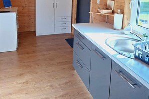 A modern kitchen with grey cabinets, a white countertop, and a sink. - Holiday Homes Close to the Seaside Beach (Mielno)