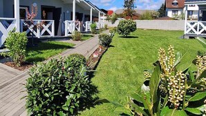 A row of white buildings with covered walkways and a well-maintained lawn in the foreground. - Holiday Homes Close to the Seaside Beach (Mielno)