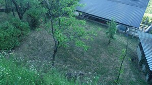 A residential area with a house featuring a sloped metal roof and a small attached garage. - Plesivica Hillside HolidayHome/Hot-Tub - 1 Bedroom (Jastrebarsko)