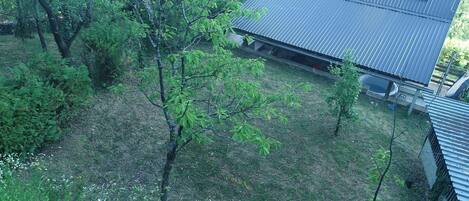 A residential area with a house featuring a sloped metal roof and a small attached garage.