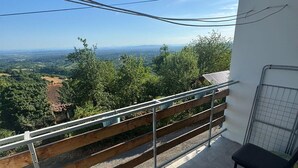 A balcony with a metal railing, a small table, and a chair. - Plesivica Hillside HolidayHome/Hot-Tub - 1 Bedroom (Jastrebarsko)