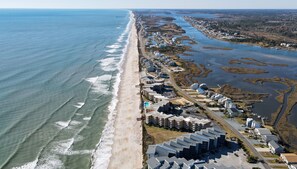 An aerial view of a coastal residential area with beachfront properties, a road, and a river. - Beach, Views, and Relaxation at "What The Shell"! (North Topsail Beach)