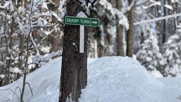 Ein verschneiter Straßenschild, das auf eine plötzliche Kurve hinweist.