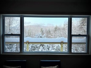 Une pièce dotée d’une grande fenêtre donnant sur un paysage enneigé.