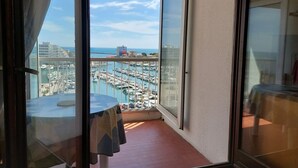 Ein Balkon mit Blick auf einen Yachthafen und Gebäude.