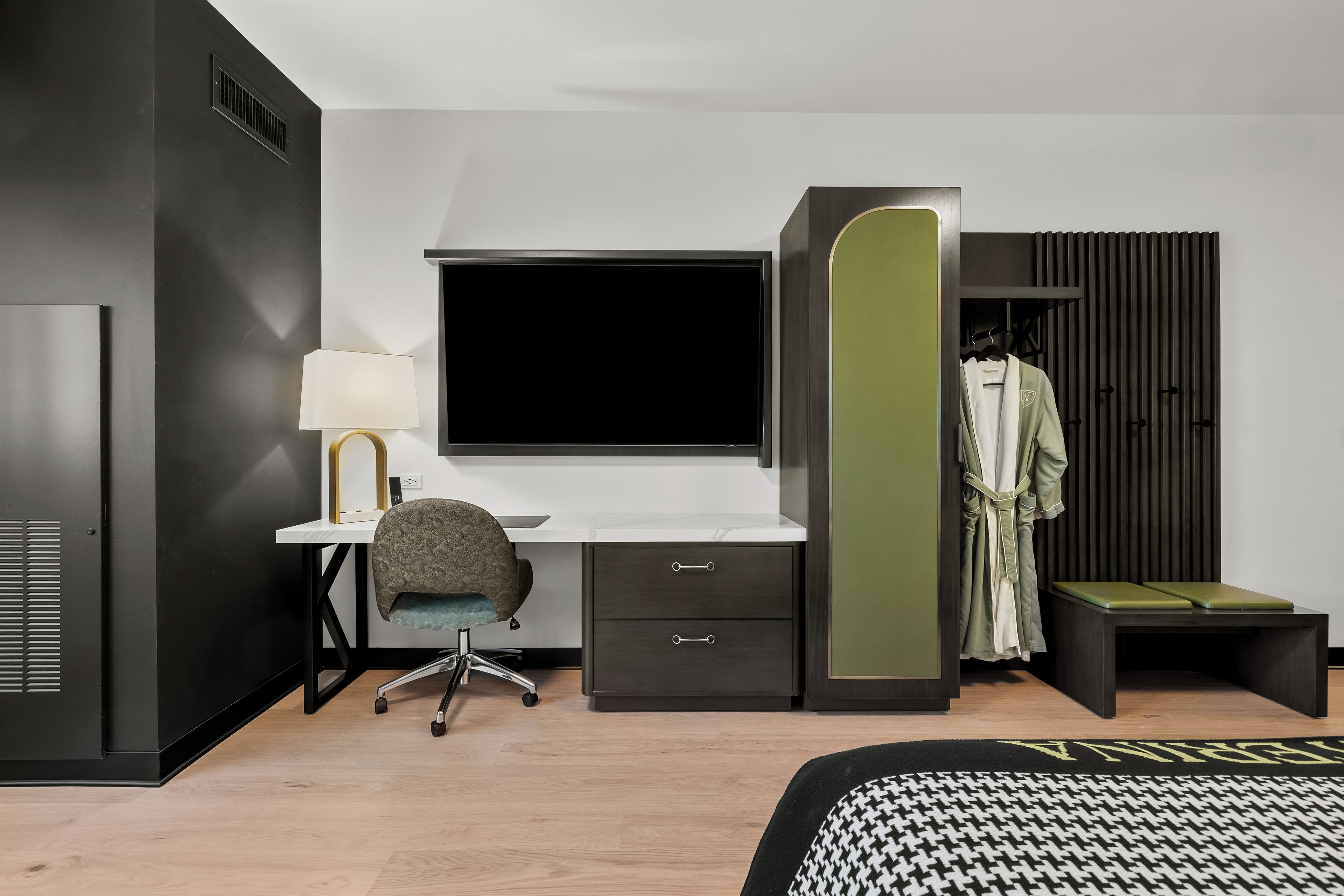 Ein modernes Schlafzimmer mit Schreibtisch, Stuhl und begehbarem Kleiderschrank.