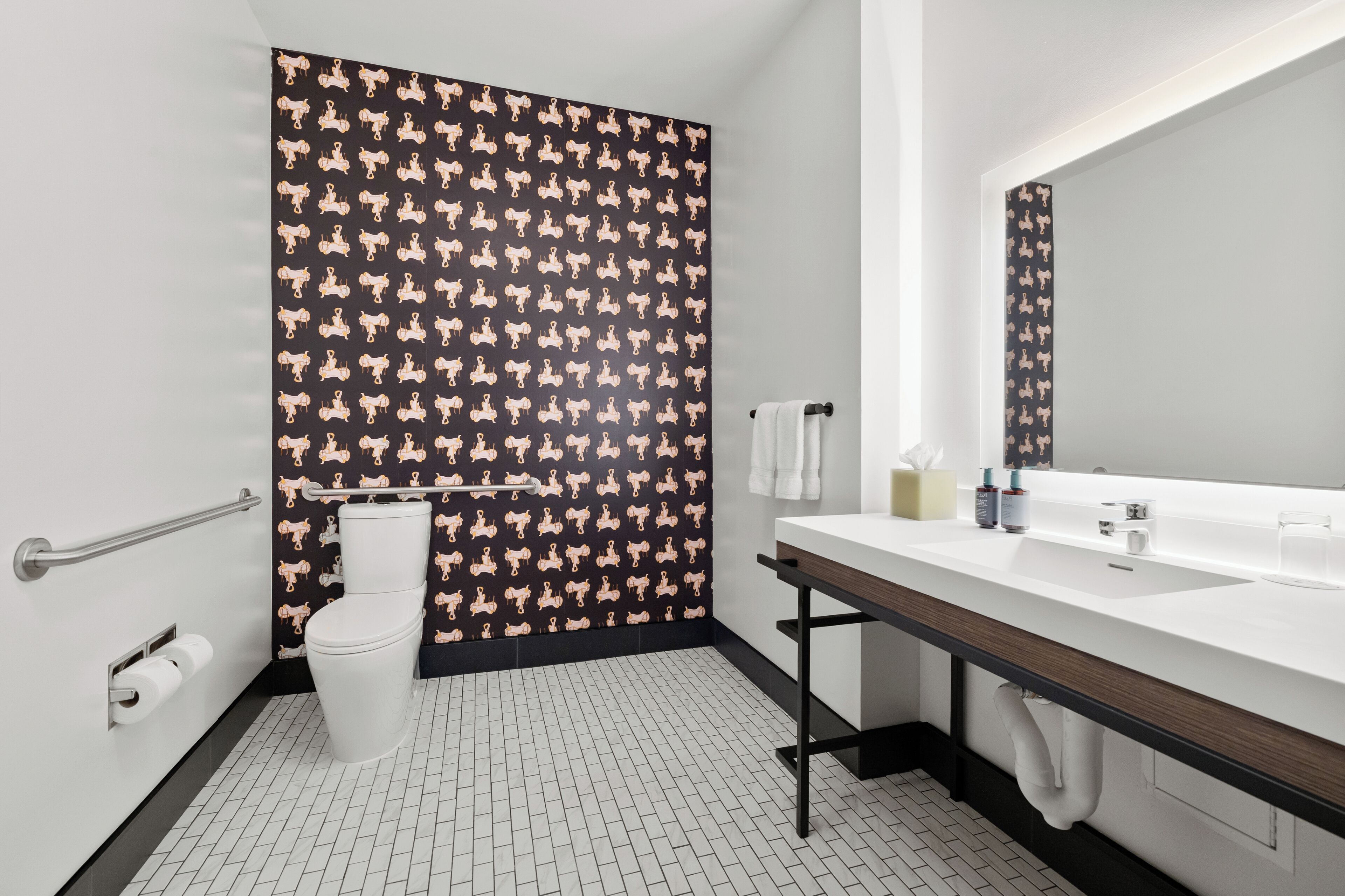A modern bathroom with a white sink, a mirror, and a toilet.
