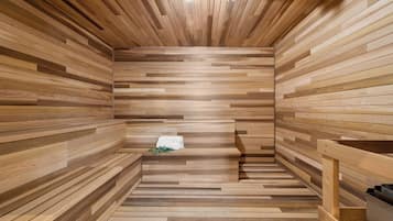 Una sauna con listones de madera en las paredes y el suelo, un banco y una toalla sobre el banco.