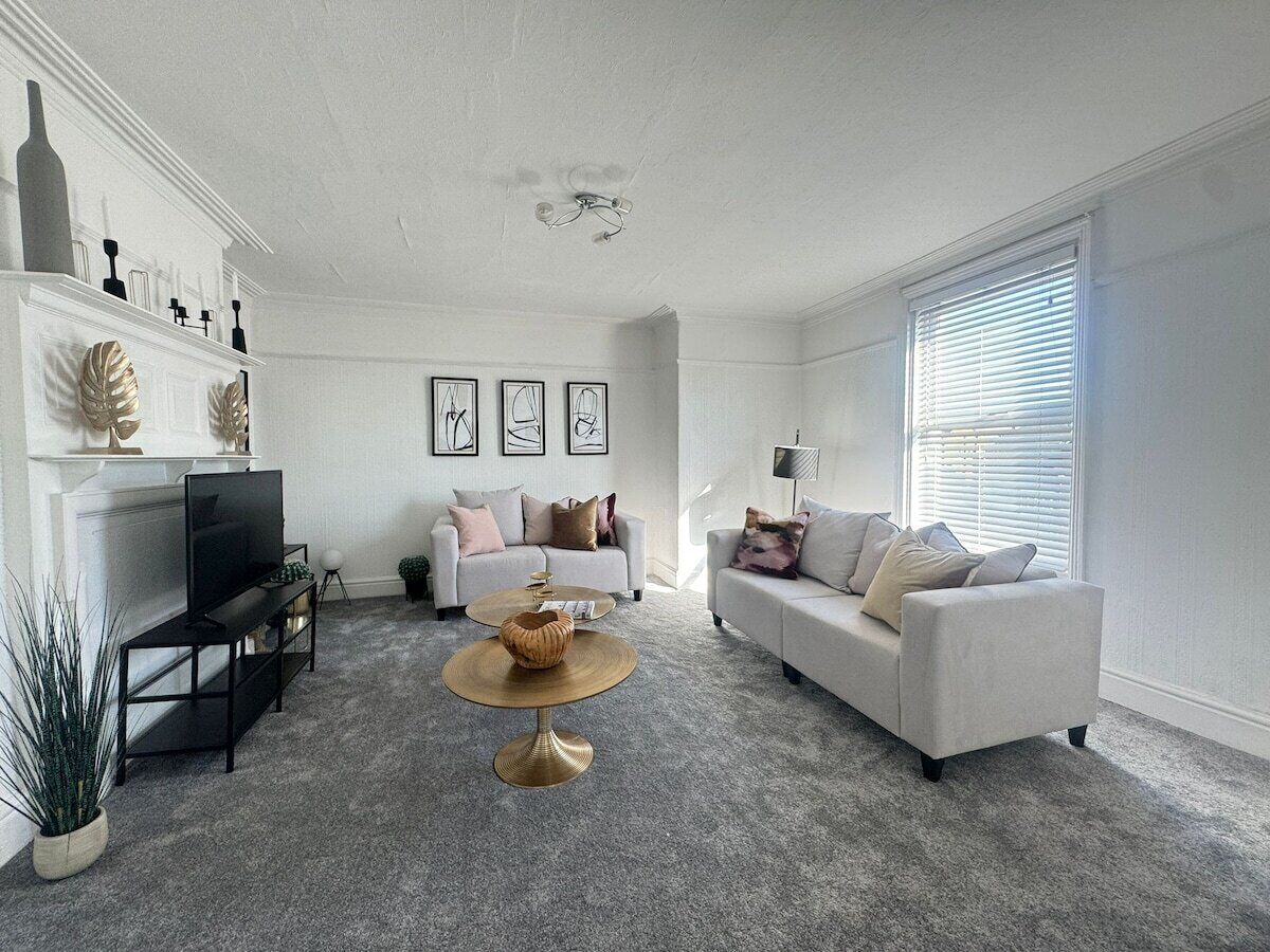 A living room with a fireplace, two sofas, a coffee table, and a television.
